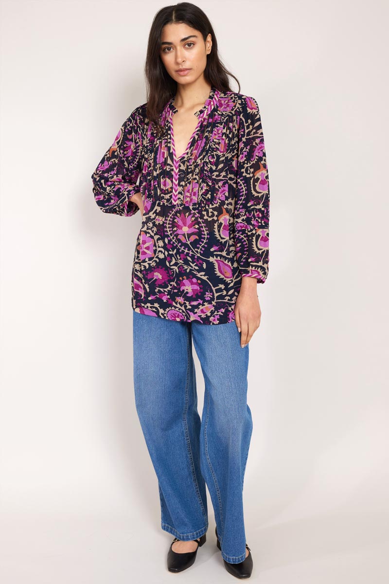 Model wears Lanya Pintuck Blouse with wide leg jeans, hand on hip