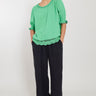 Model wears East Lena Green Cotton Blouse, hands in pockets