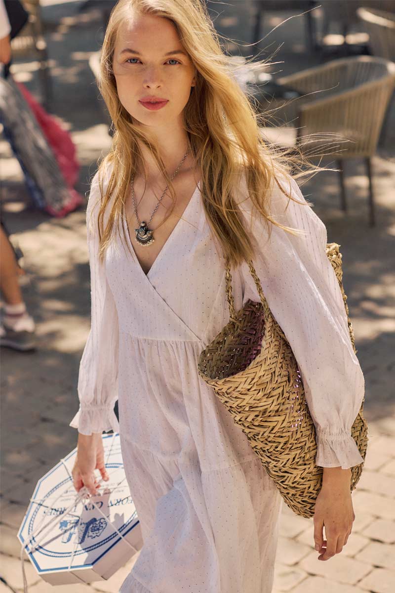 Model wears East Lesia White Dress and Straw Bag