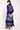 Back view of model wearing East Chrissie Batik Navy Satin Dress