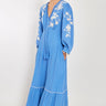 Model wears East Fern Embroidered Blue Cotton Gauze Dress hands in pockets