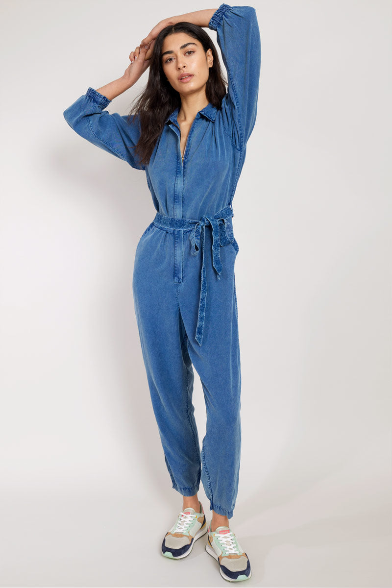 Model has arms up wearing East Iona Jumpsuit front view
