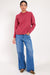 Model wears a raspberry colour merino wool jumper.