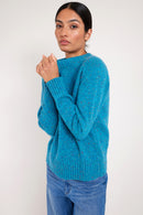 Model wears a peacock blue coloured merino wool jumper.