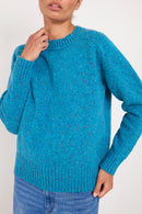 Model wears a peacock blue coloured merino wool jumper.